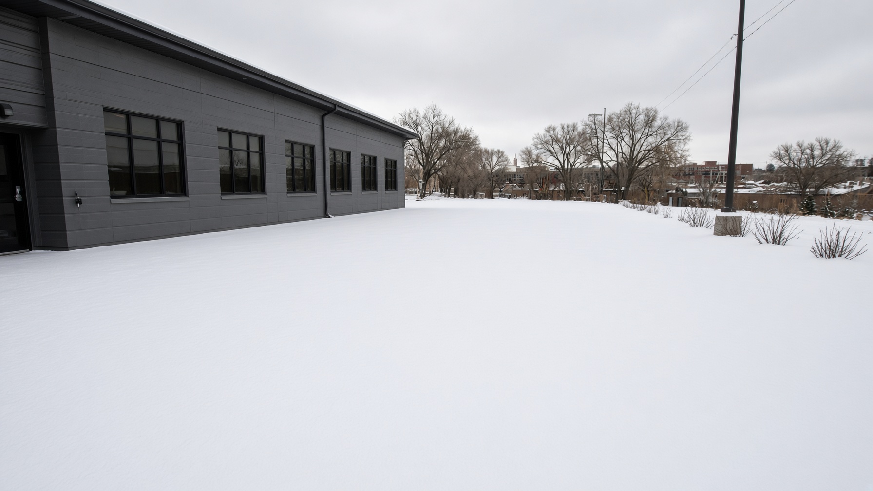 Placeholder photo of a commercial drive buried in snow before plowing.